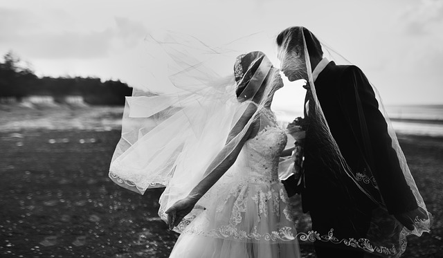 ženich s nevěstou – černobílá fotografie, polibek v přírodě